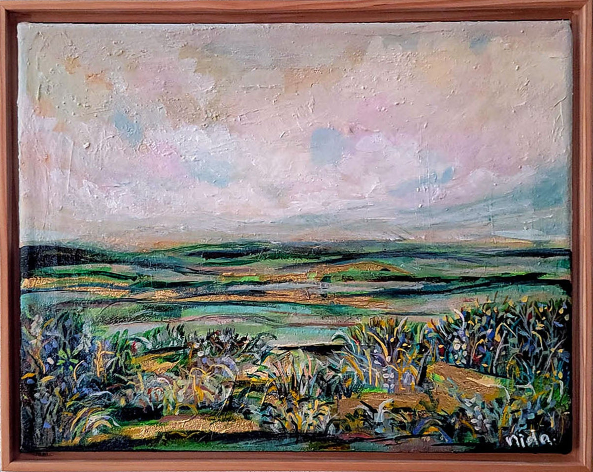 Framed painting of a landscape with a wooden frame on a white wall