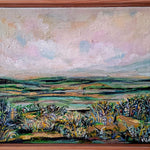 Framed painting of a landscape with a wooden frame on a white wall