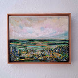 Framed painting of a landscape with a wooden frame on a white wall